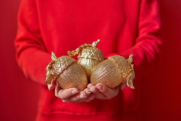 Image showing Woman in red holds Christmas decoration.