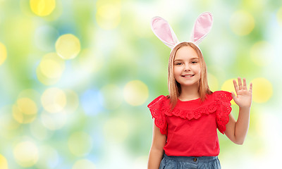 Image showing happy girl wearing easter bunny ears waving hand