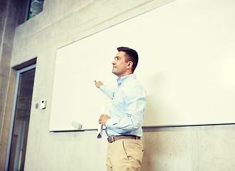 Image showing teacher pointing marker to white board at lecture