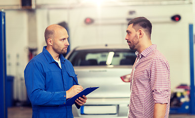 Image showing auto mechanic with clipboard and man at car shop