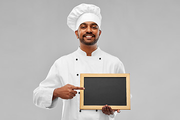 Image showing happy male indian chef in toque with chalkboard