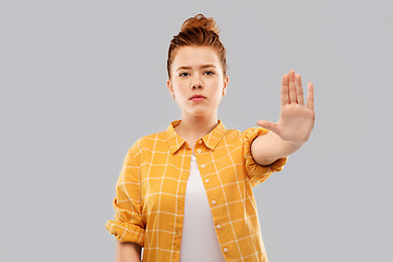 Image showing red haired teenage girl making stopping gesture