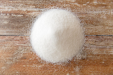Image showing close up of white sugar heap on wooden table