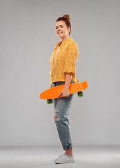 Image showing red haired teenage girl with short skateboard