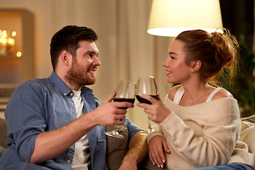 Image showing happy couple drinking red wine at home in evening