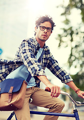 Image showing young hipster man with bag riding fixed gear bike