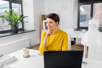 Image showing happy businesswoman sitting at office table