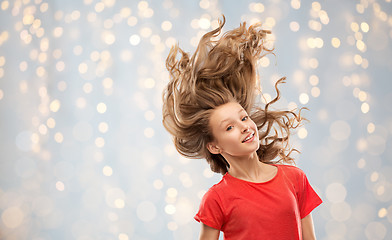 Image showing smiling teenage girl in red with long wavy hair