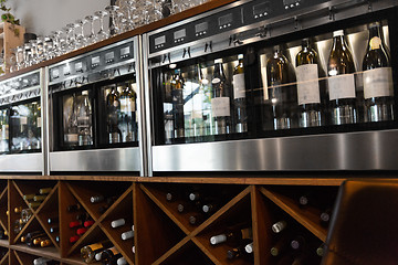 Image showing close up of wine bottles in dispenser at bar