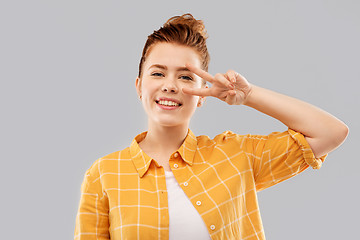 Image showing smiling red haired teenage girl showing peace