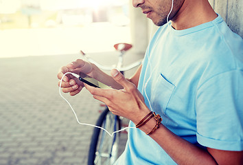 Image showing man with earphones and smartphone listening music