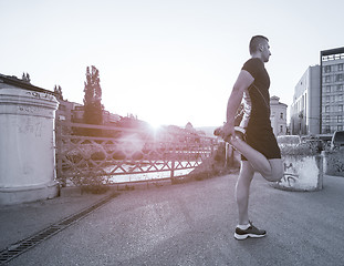 Image showing athlete man warming up and stretching