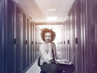 Image showing engineer working on a laptop in server room