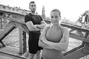 Image showing young couple jogging across the bridge in the city