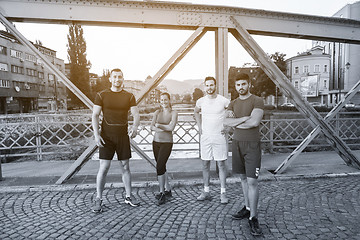 Image showing group of young people jogging across the bridge