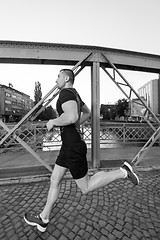 Image showing man jogging across the bridge at sunny morning