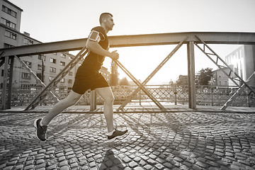 Image showing man jogging across the bridge at sunny morning