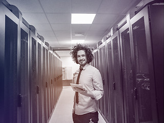 Image showing IT engineer working on a tablet computer in server room