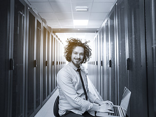 Image showing engineer working on a laptop in server room