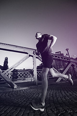 Image showing man jogging across the bridge in the city