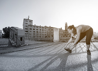 Image showing athlete woman warming up and stretching