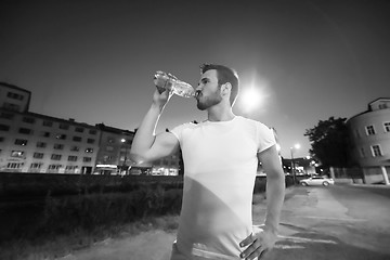 Image showing man drinking water after running session