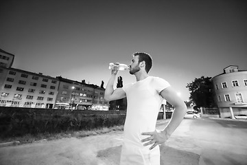 Image showing man drinking water after running session