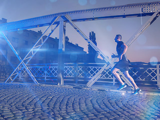 Image showing man jogging across the bridge in the city