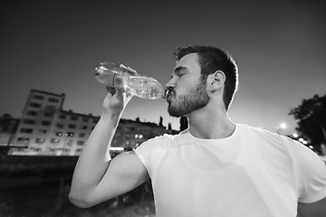 Image showing man drinking water after running session