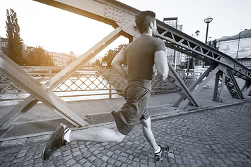 Image showing man jogging across the bridge at sunny morning