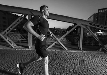 Image showing man jogging across the bridge in the city