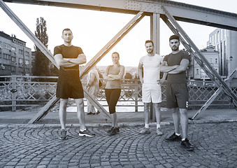 Image showing group of young people jogging across the bridge