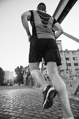 Image showing man jogging across the bridge at sunny morning