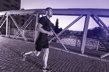 Image showing man jogging across the bridge in the city