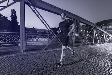 Image showing man jogging across the bridge in the city