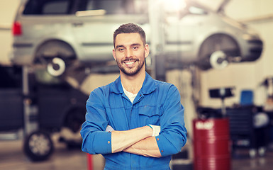 Image showing happy auto mechanic man or smith at car workshop