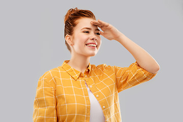 Image showing smiling red haired teenage girl looking far away