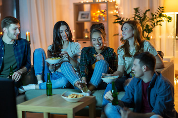 Image showing friends with drinks and snacks watching tv at home