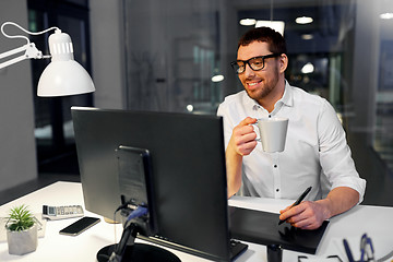 Image showing designer with pen tablet drinking coffee at office