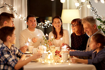 Image showing family with sparklers having tea party at home