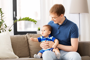 Image showing happy father with baby son sitting on sofa at home