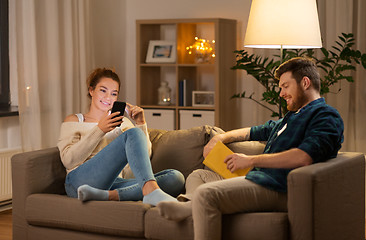 Image showing couple with smartphone and book at home