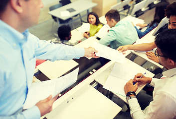 Image showing teacher giving tests to students at lecture hall