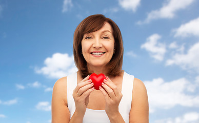 Image showing portrait of smiling senior woman holding red heart