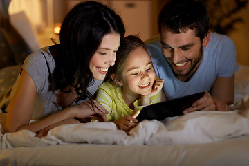 Image showing family with tablet pc in bed at night at home