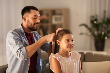 Image showing father braiding daughter hair at home