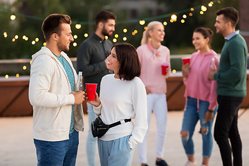 Image showing friends with drinks in party cups at rooftop