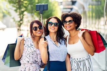 Image showing women with shopping bags taking selfie outdoors