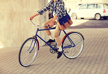 Image showing young hipster man with bag riding fixed gear bike