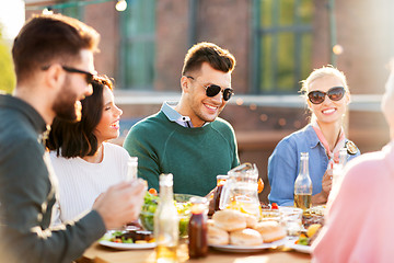 Image showing happy friends eating and drinking at rooftop party